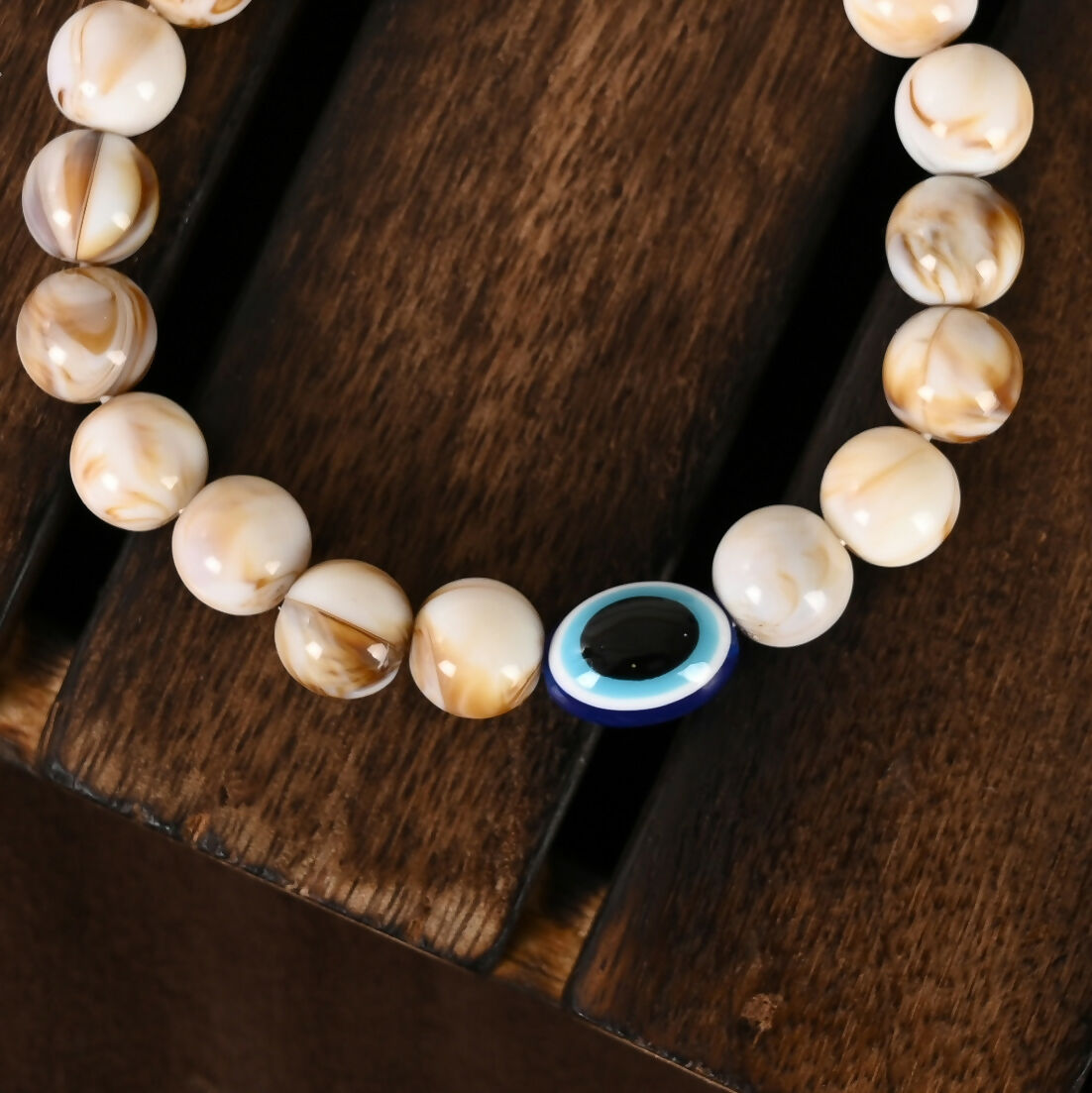 NVR Women & Men Cream-colored Evil Eye Elasticated Rakhi With Roli Chawal - Swadesiicart