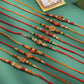 NVR Men Set of 10 Floral Design Red Artificial Stones and Beads Thread Rakhi with Roli Chawal Chandan & Mishri - Swadesiicart