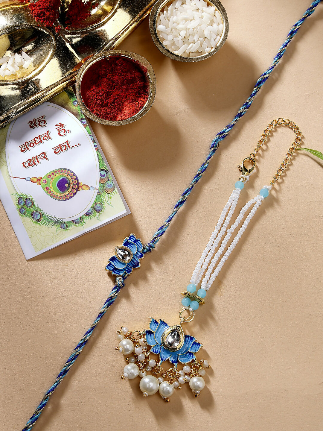 NVR Women & Men Set of 2 Blue Lotus Shape Kundan-Studded & Beaded Handcrafted Wraparound Rakhi Set With Roli Chawal | Swadesiicart